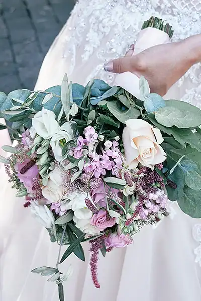 Onelovephoto Eine Braut hält einen Strauß aus pastellfarbenen Blumen, darunter weiße und errötende Rosen, Lavendelblüten und Grünzeug, vor dem Hintergrund eines Hochzeitskleides aus Spitze. Hochzeitsfotografie in Mannheim und Heidelberg Onelovephoto Eine Braut hält einen Strauß aus pastellfarbenen Blumen, darunter weiße und errötende Rosen, Lavendelblüten und Grünzeug, vor dem Hintergrund eines Hochzeitskleides aus Spitze. Hochzeitsfotografie in Mannheim und Heidelberg